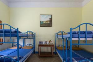 Cette chambre comprend 3 lits superposés bleus et une table. dans l'établissement KSTDC Hotel Mayura Bhuvaneshwari Kamalapur, à Hampi