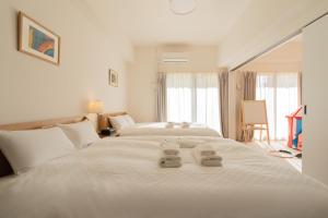 a bedroom with two beds with towels on the bed at 谷町君ホテル WE 難波28 in Osaka
