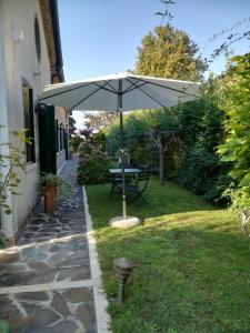 a picnic table under an umbrella in a yard at Casa Pianta in Cavallino-Treporti