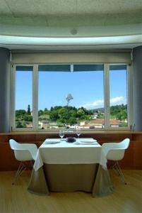 a room with a table and chairs with a view of the ocean at Colón Tuy in Tui