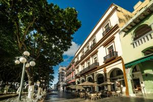 ベラクルスにあるHotel Imperialのテーブルと傘と建物のある街道