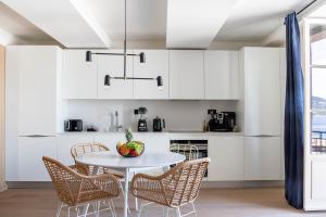 a kitchen with white cabinets and a table and chairs at Maison Bellevue in Saint-Tropez