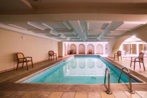 a swimming pool with chairs and tables in a building at Hotel Imperial in Veracruz
