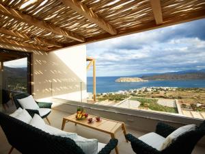 a living room with a balcony overlooking the ocean at Cayo Exclusive Resort & Spa in Elounda