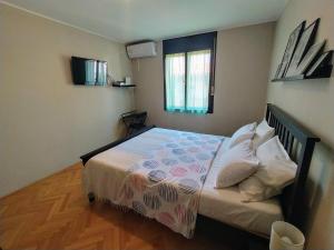a small bedroom with a bed and a window at Apartments Villa Sabina in Pula