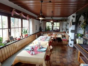 un comedor con mesas, sillas y ventanas en Hotel Landgasthof Ratz, en Rheinau