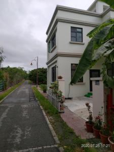 una calle vacía frente a una casa blanca en 青禾軒, en Fuli