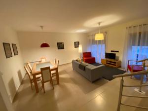 sala de estar con sofá, mesa y sillas en Villas Mare Residence, en Nazaré