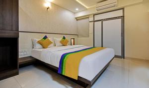 a hotel room with a white bed and white walls at Treebo Trip Deluxe Inn Pondibazar in Chennai