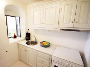 a kitchen with a sink and a bowl of fruit on the counter at Alafouzou Cave Loft by SV in Oia
