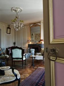 貝葉的住宿－Hôtel particulier "le clos de la croix"，客厅配有椅子和吊灯。