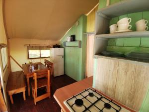 una pequeña casa con cocina y comedor con fogones en Sunflower Camping, en Novigrad Istria