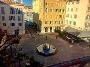Cette chambre offre une vue sur une cour située dans une ville dotée d'une fontaine. dans l'établissement Le cocon de Louise-Vieux Port, à Marseille