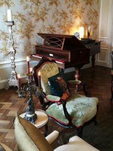 un soggiorno con pianoforte e sedia di Hôtel particulier "le clos de la croix" a Bayeux