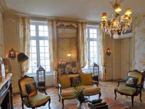 a living room with chairs and a chandelier at Hôtel particulier "le clos de la croix" in Bayeux