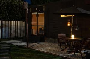 a patio with a table and an umbrella at night at HOH - Chalet Frodo in Matamata