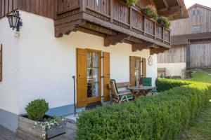 a porch of a house with a table and a balcony at Christophenhof in Oberaudorf