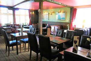 a dining room with tables and chairs in a restaurant at The White Horse in Beyton