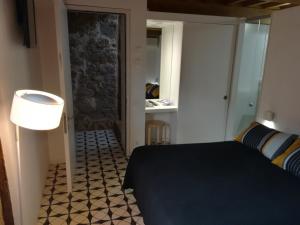 a bedroom with a black bed and a bathroom at Apartamento Zocailla in Gata