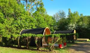 Avrillé的住宿－Camping les Mancellieres，种有树木和植物的花园中的吊舱