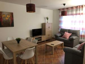 a living room with a couch and a table at Alojamientos El Chorro in Los Navalucillos