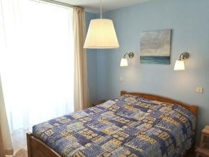 a bedroom with a bed with a quilt on it at Chez Gustou in Chaudes-Aigues