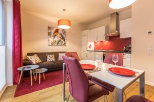 a kitchen and living room with a table and chairs at Ferienwohnung Büsumperle Rot in Büsum