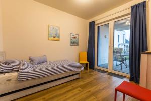 a bedroom with a bed and a sliding glass door at Ferienwohnung Büsumperle Rot in Büsum