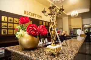 una cruz de oro en un mostrador con un jarrón de rosas en Viand Hotel - Premium All Inclusive, en Sunny Beach