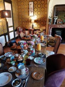 una mesa llena de platos y tazones de comida en Hôtel particulier "le clos de la croix" en Bayeux