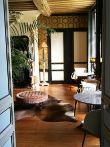 sala de estar con mesa, sillas y sofá en Hôtel particulier "le clos de la croix", en Bayeux