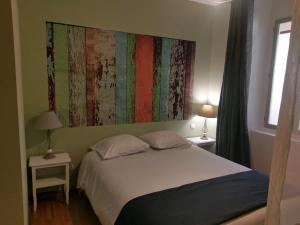 1 dormitorio con 1 cama y una pintura en la pared en Résidence du Parc avec Sauna, en Eaux-Bonnes