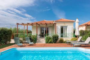 a villa with a swimming pool and a house at Sun, Sand, & Seclusion - Artemis with Private Pool in Finikounta
