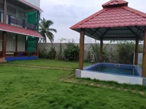 uma casa com uma piscina e um gazebo em Waves Beach House em Pondicherry
