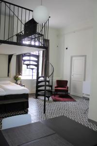 Mäntsälä的住宿－Hotelli Kartanon Meijeri，一间卧室设有双层床和螺旋楼梯。