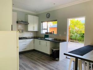 a large kitchen with white cabinets and a window at Habitat in Clarens