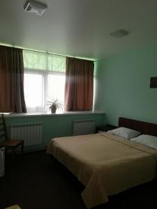 クルガンにあるHotel Kniiekotのベッドルーム1室(ベッド2台、窓付)