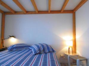 a bedroom with a bed with blue and white stripes at Le 46 Clos Vert in Erquy