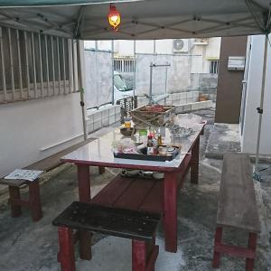 糸满民宿 ＯＢ（guest house OB）的一张带遮阳伞下长凳的野餐桌