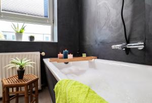 a bathroom with a bath tub with a green towel at MD-8 Kleiststrasse 4 - Zentral nur 5min bis zur Innenstadt - 2Schlafzimmer-Smart TV-Badewanne-Innenhoflage in Magdeburg +6 photos