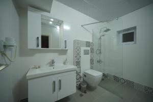 a white bathroom with a sink and a toilet at Pashabelle Hotel in Goreme