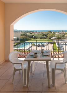 a table and chairs on a balcony with a view at Catamaran Corfu Aparthotel in Acharavi