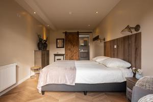sypialnia z dużym łóżkiem z drewnianym zagłówkiem w obiekcie Herberg de Appelgaard w mieście Barneveld