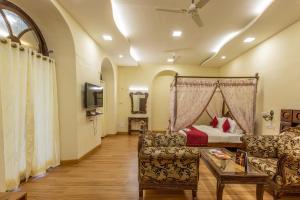 a bedroom with a bed and a couch and a table at KSTDC Hotel Mayura Pine Top Nandi Hills in Nandi