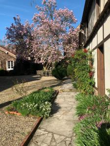 a garden with flowers on the side of a building at Le Puits D'Angle in Thibivillers