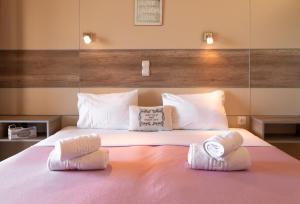 1 dormitorio con 1 cama con 2 toallas en Catamaran Corfu Aparthotel, en Acharavi