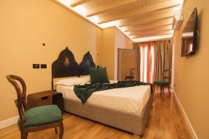 a bedroom with a bed and chairs in a room at Leano Agriresort in Piazza Armerina