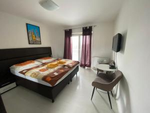 a bedroom with a bed and a tv and a chair at Penzión Oáza in Trnava