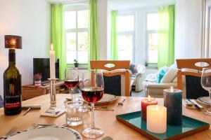 una mesa de comedor con copas de vino y velas en *NEU* Zentral (nur 5min bis zur Innerstadt) *Netflix & Amazon TV* en Magdeburgo