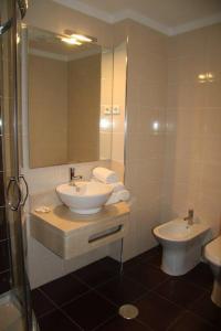 a bathroom with a sink and a toilet at Hotel Katia in Chaves +18 photos